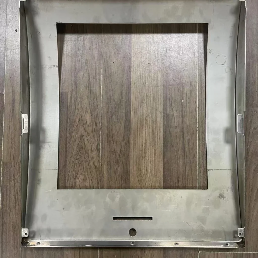 Back side of stamped 304 stainless steel panel showing punched openings, clip brackets and screw holes
